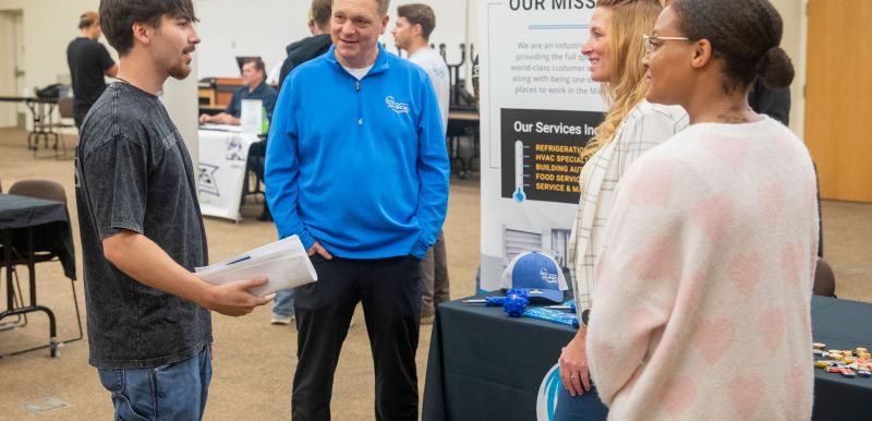 student talking with three reps from SCR about job opportunities
