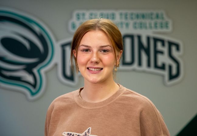 Jenna Boos smiling in front of Cyclones logo