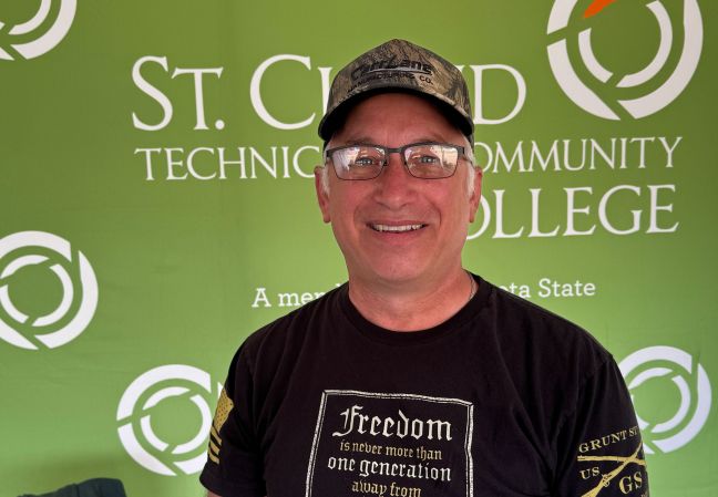 Loren Popp in front of a green backdrop with SCTCC logo
