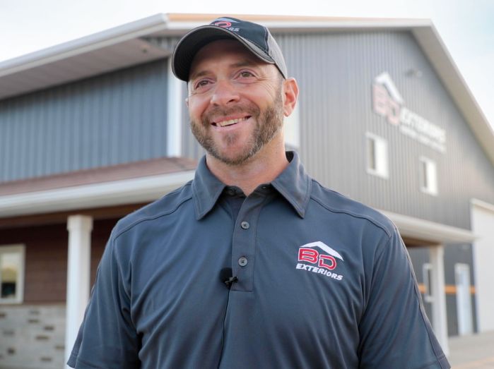 Brian Donnay smiling with the BD Exteriors building in the back