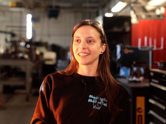 Mikayla Asfeld sitting in the Welding Lab