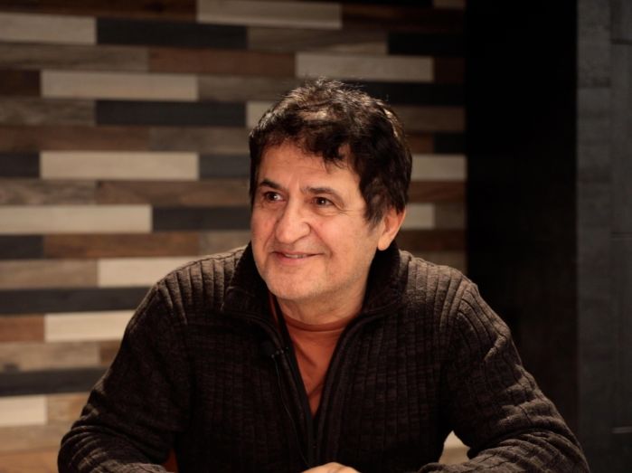 Soheyl Missaghi at a table and smiling