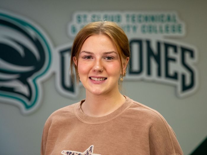 Jenna Boos smiling in front of Cyclones logo