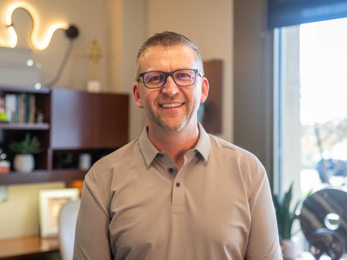 Trevor Akervik smiling in his office
