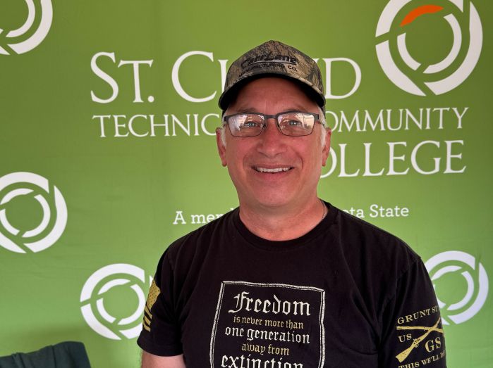 Loren Popp in front of a green backdrop with SCTCC logo