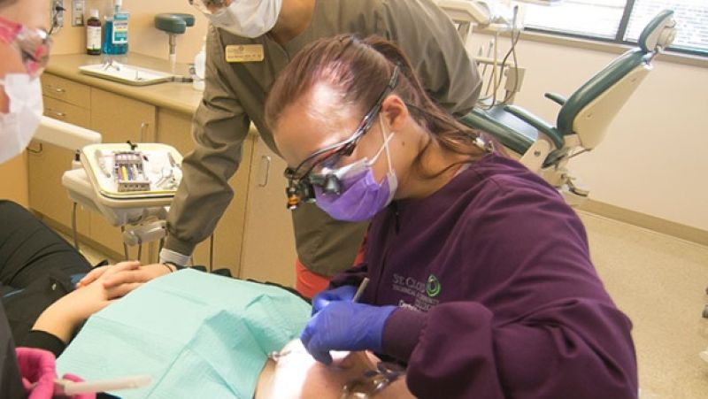 dental hygiene students working with a patient