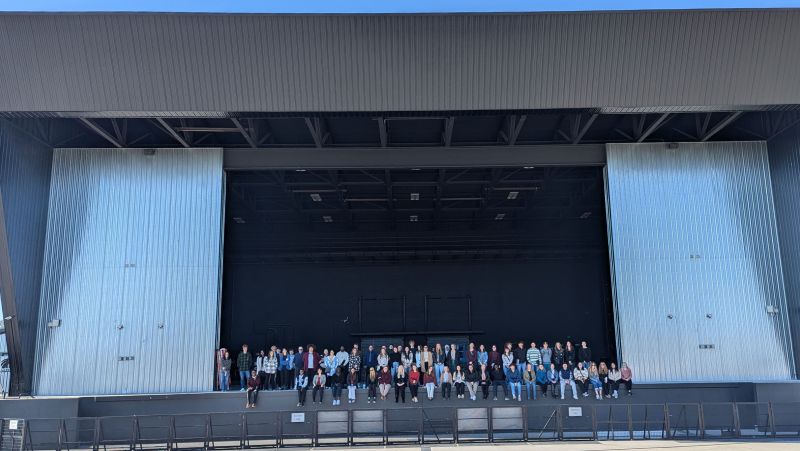 students sit on the stage at the ledge ampitheater