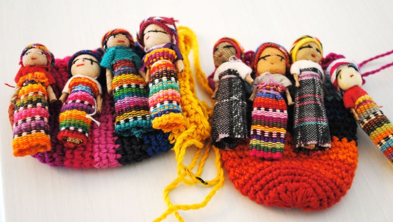 eight worry dolls lined up