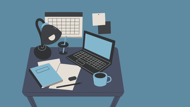 desk set up with lamp, planner, computer, notebook, and pen