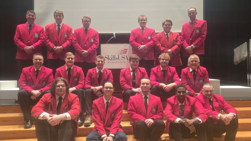 Large group of skills students and instructors in red jackets posing