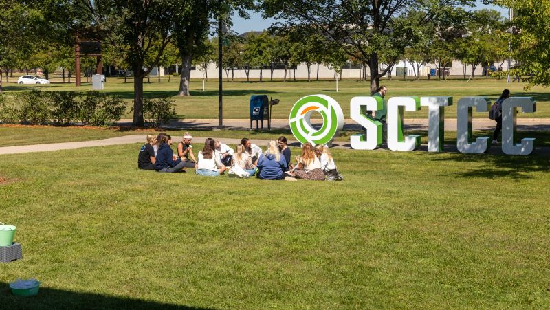 students sitting in the grass outside SCTCC