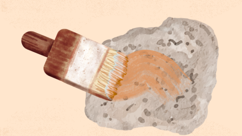 a paintbrush painting a rock