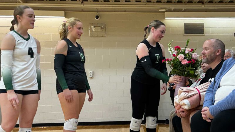 Makenzie handing family members a bouquet at the game
