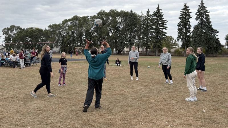 Volleyball team outdoors setting the ball in a circle