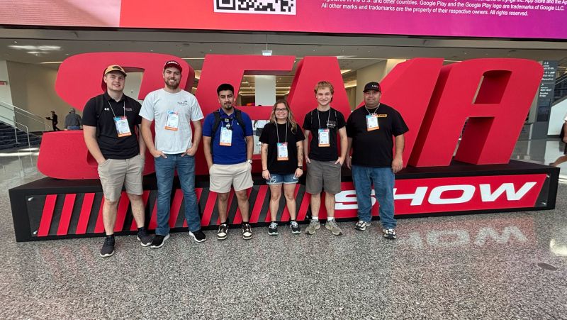 Five SCTCC folks in front of a giant SEMA statue