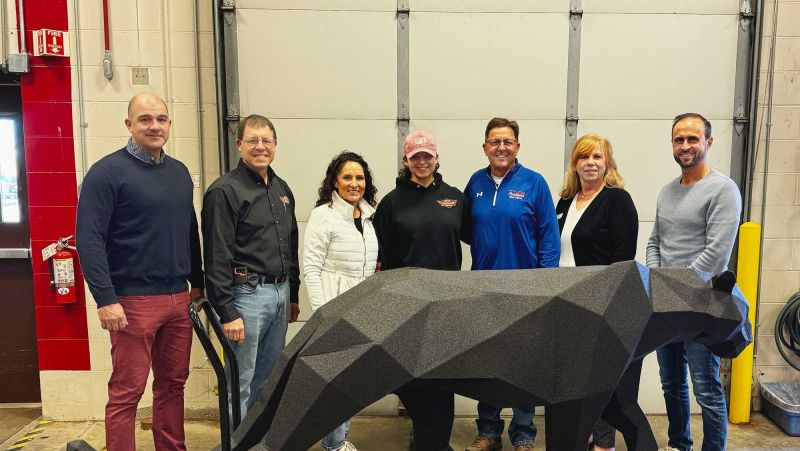 Group of people behind the welded panther smiling