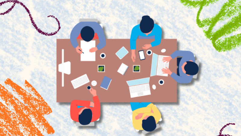 group of five people sitting around a table with various tasks, viewed from above