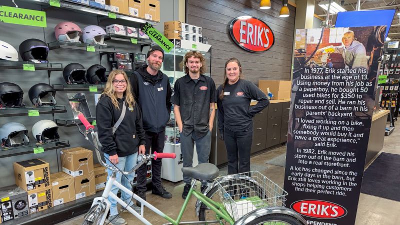 student and Erik's bike shop employees pose with freshly painted bike