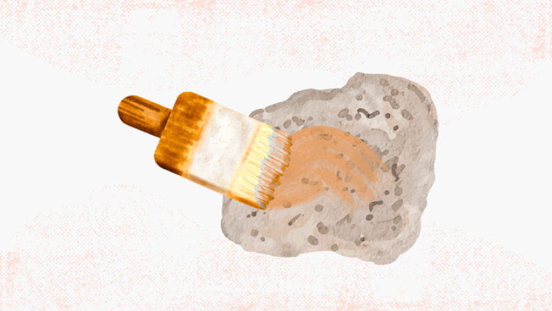 a paintbrush painting a rock