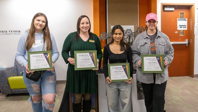 four winners of art contest holding their certificates