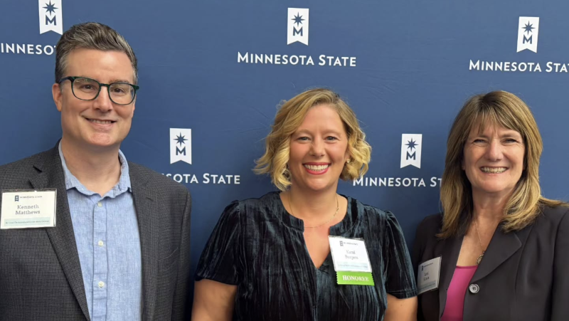 Ken, Kami, and Lori in front of a MinnSTate backdrop
