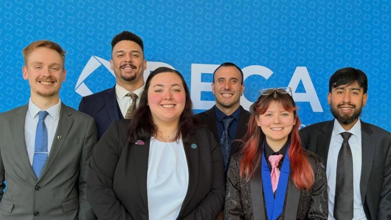 Deca team members in front of backdrop in two rows