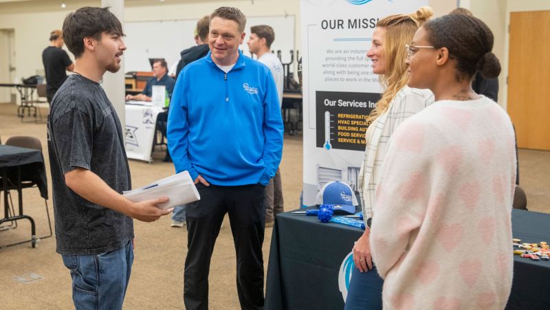 student talking with three reps from SCR about job opportunities