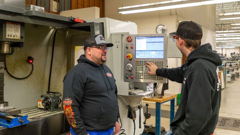 two CNC students work on the machine in the SCTCC lab