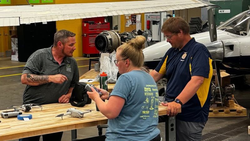 Zack helps out two teachers with drones in the Aircraft lab