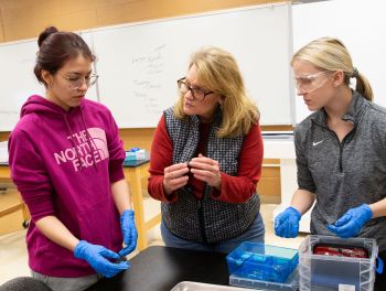 Jen Evens talking to two students in bio lab