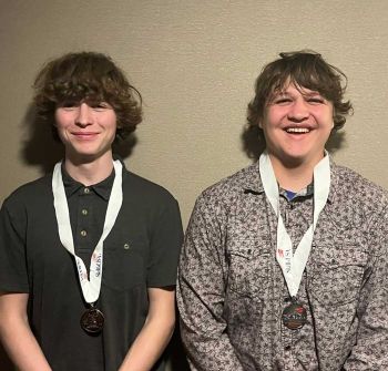 Two HVAC students with medals around their nec