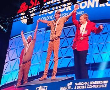 three people on a podium for winning skills competition