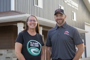 Becky and Brian smiling with BD Exteriors building in background