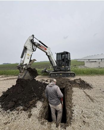 Jake Mackedanz with skidloader digging up a section marker