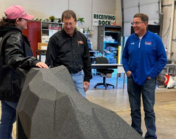 Three folks talking next to panther