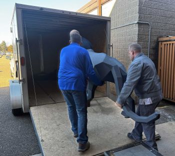 three people loading the panther into a trailer