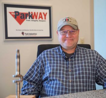 Matt Lindberg sitting in a chair with ParkWay sign behind him