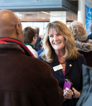 Pres Kloos smiles as she talks to someone