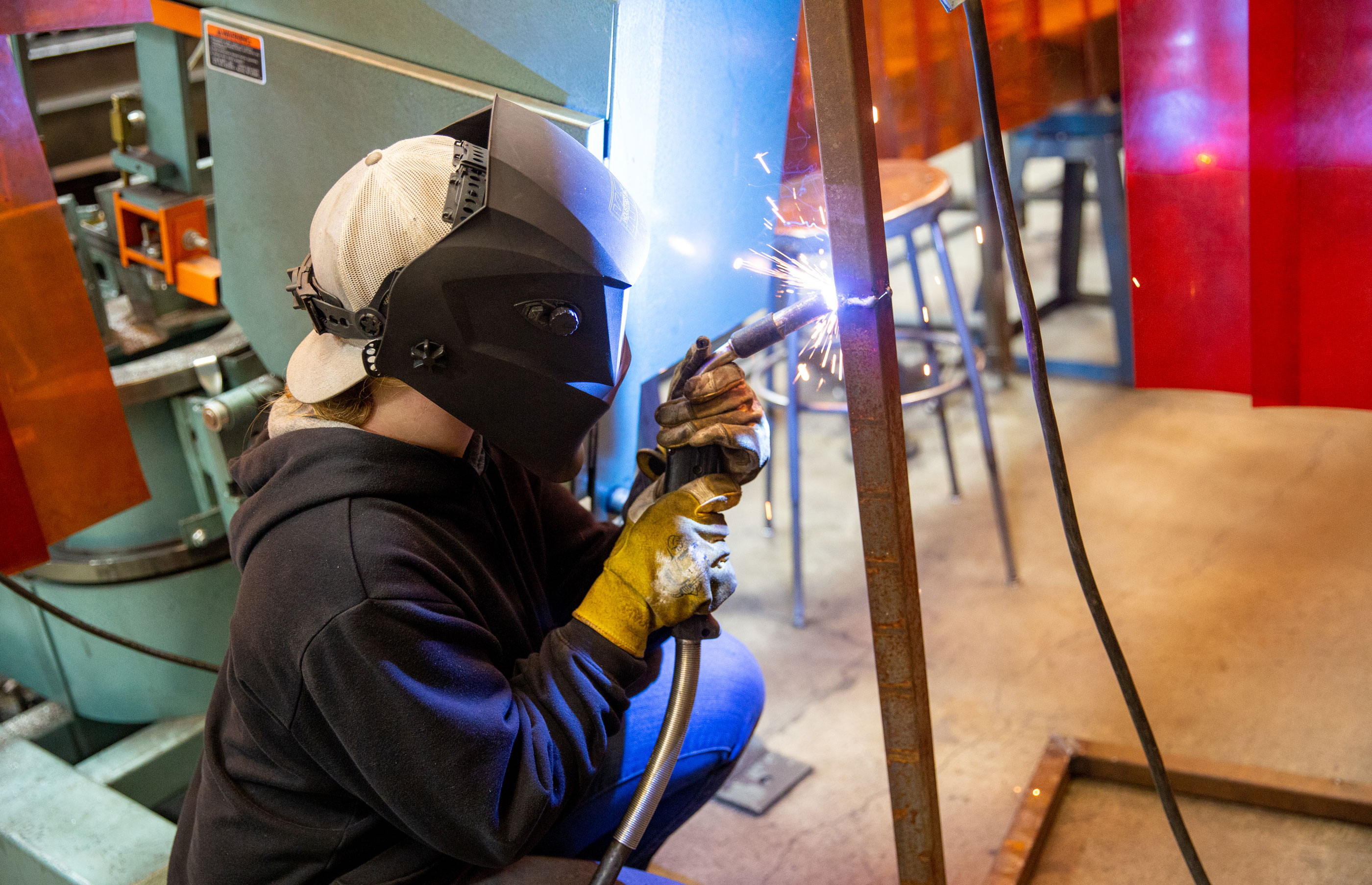 Welding student with sparks