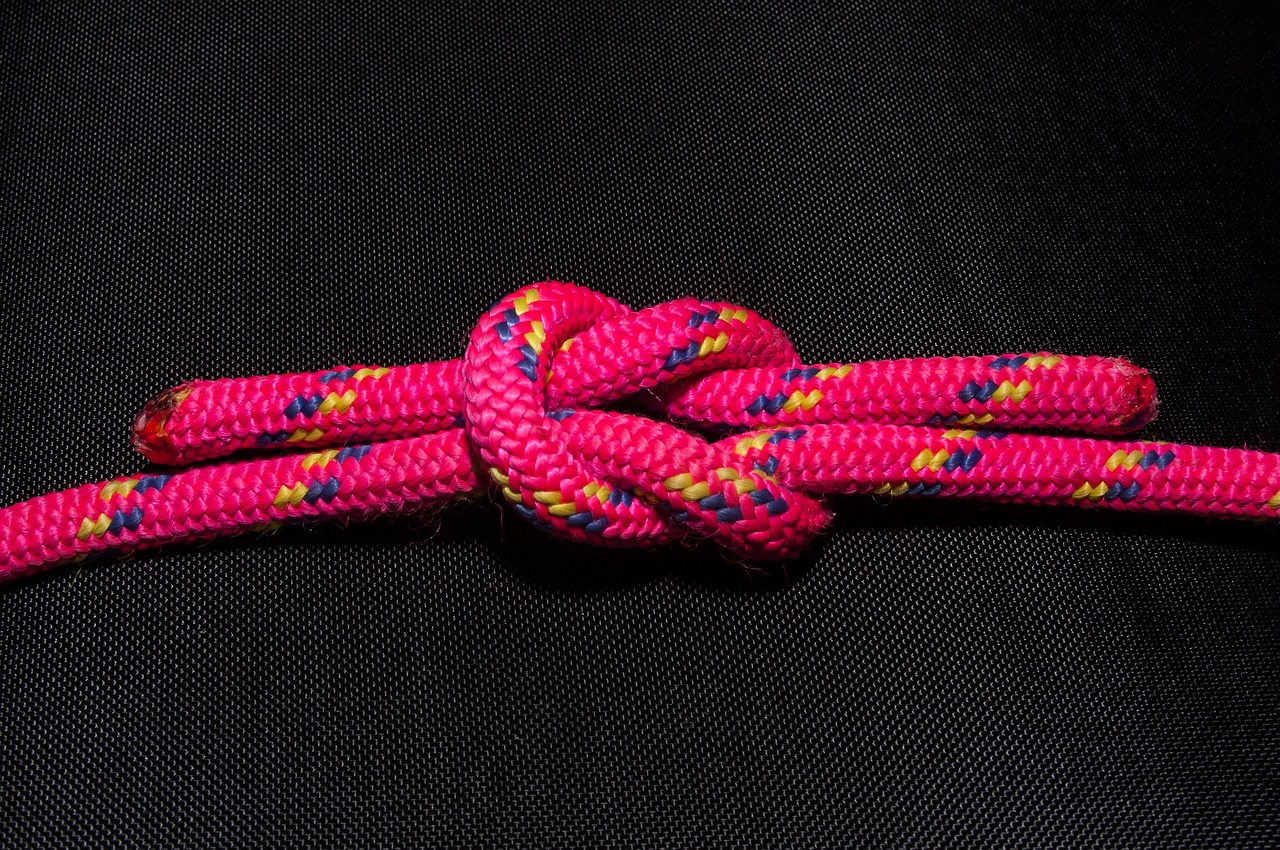 pink rope in a cross knot on black background