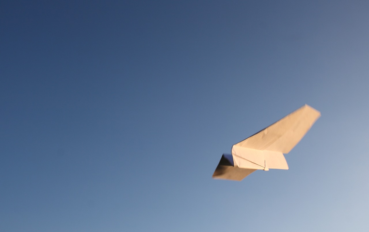 paper airplane against blue sky