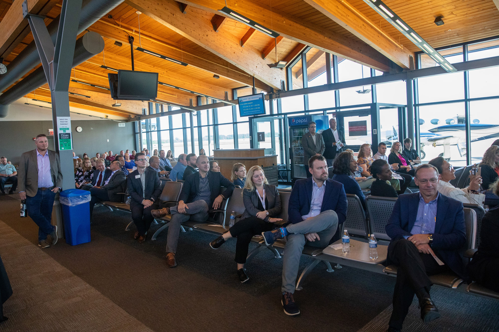 Audience sitting in the terminal at St. Cloud Airport listening to speakers at event