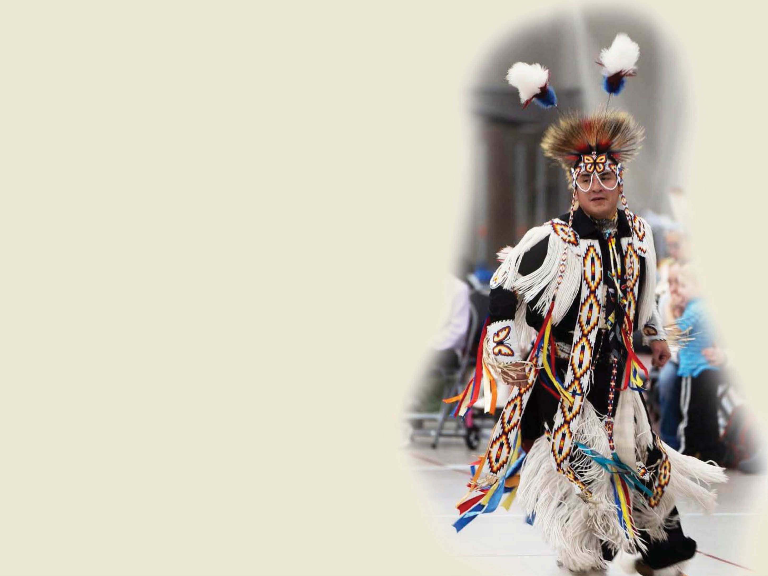 male powwow dancer in full regalia on a tan background