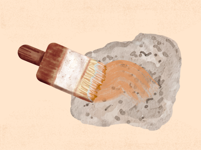 a paintbrush painting a rock