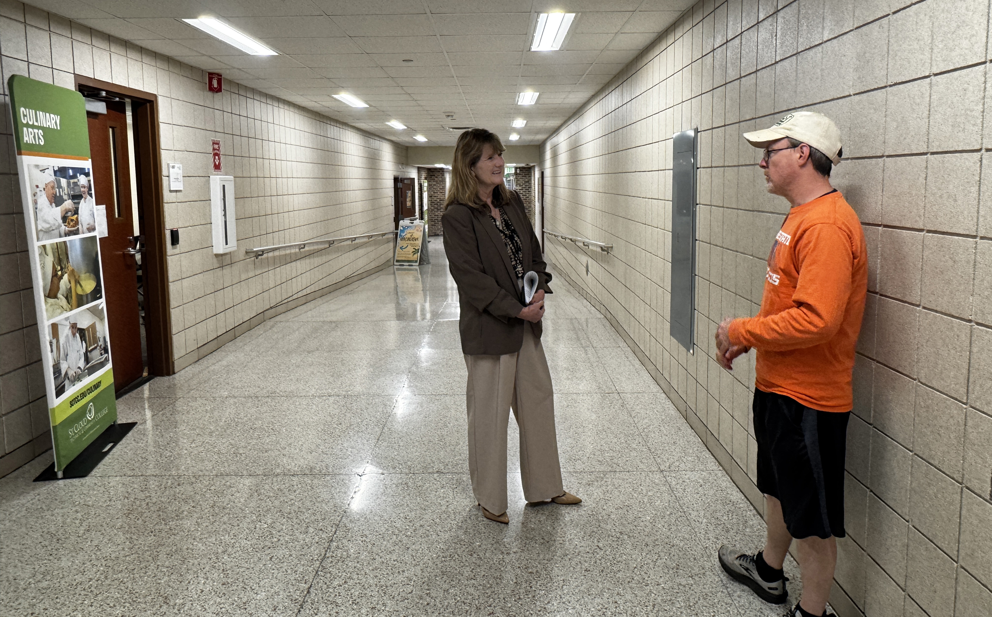 Lori Kloos chats with a student in the hall