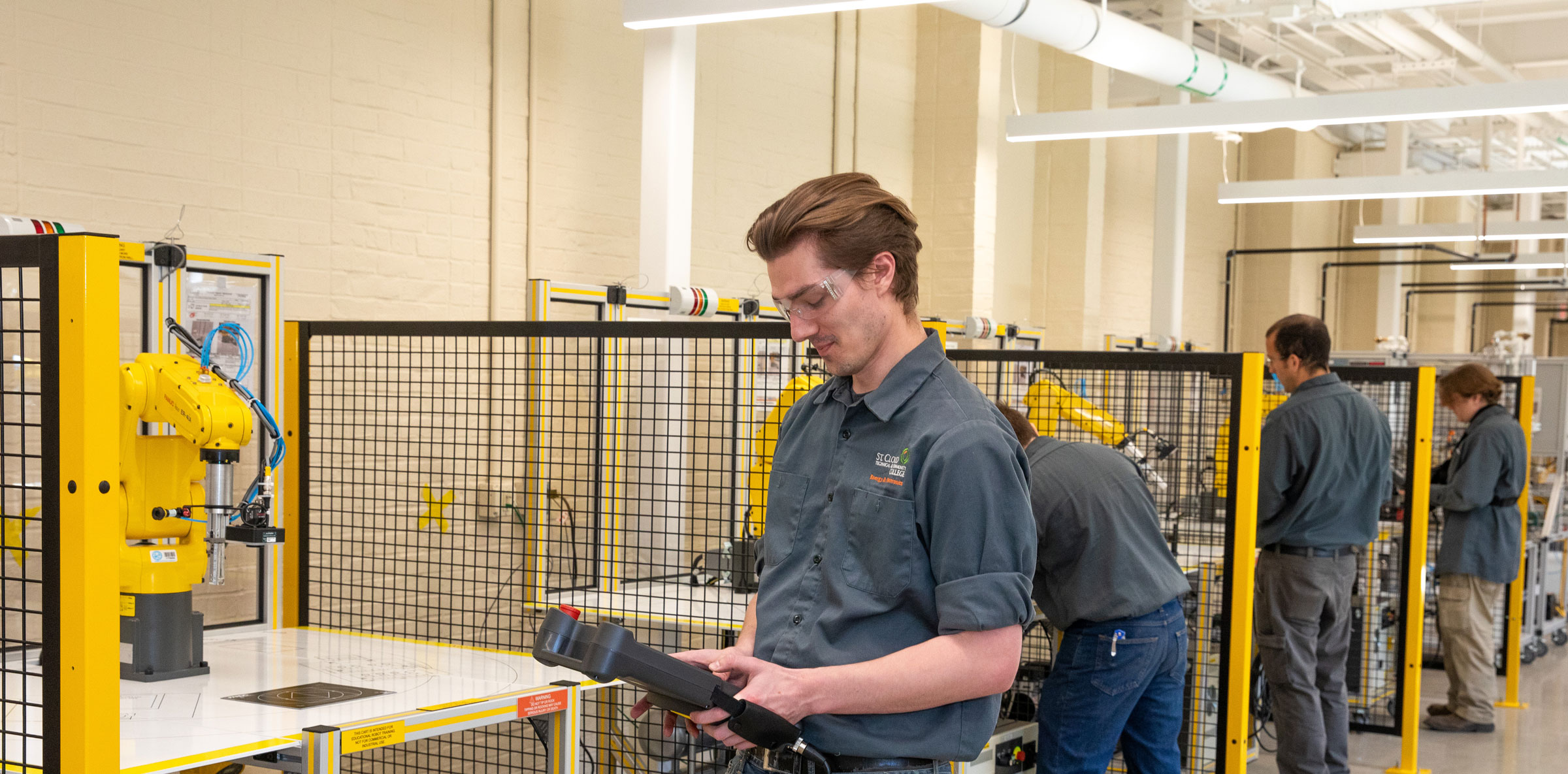 student works on a fanuc robot in the AMC